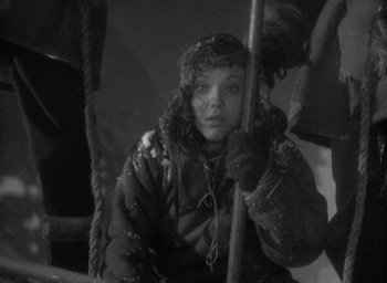 Movie still from “Lost Horizon” (1937), directed by Frank Capra – A young girl holding onto a pole in the snow; Medium shot, High angle