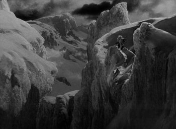 Movie still from “Lost Horizon” (1937), directed by Frank Capra – A man riding skis on top of a snow covered slope; Extreme Wide shot, High angle
