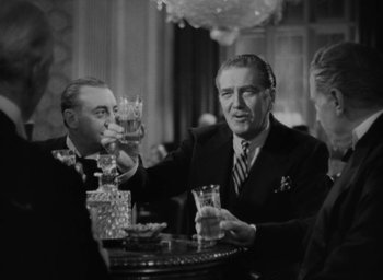 Movie still from “Lost Horizon” (1937), directed by Frank Capra – Three men sitting at a table with drinks in front of them; Medium shot, Low angle