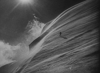 Movie still from “Lost Horizon” (1937), directed by Frank Capra – A person riding a surf board on a body of water; Extreme Wide shot, Low angle