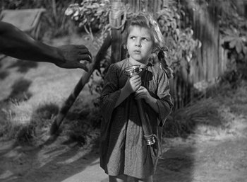 Movie still from “Mighty Joe Young” (1949), directed by Ernest B. Schoedsack – An old photo of a young boy holding a stick; Medium shot, High angle