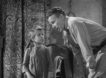 Movie still from “Mighty Joe Young” (1949), directed by Ernest B. Schoedsack – An old photo of a man and a little girl; Medium shot, Over the shoulder angle