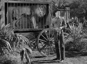 Movie still from “Mighty Joe Young” (1949), directed by Ernest B. Schoedsack – A man standing in front of a horse drawn carriage; Wide shot, Low angle