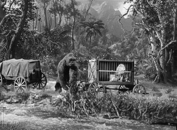 Movie still from “Mighty Joe Young” (1949), directed by Ernest B. Schoedsack – An old photo of a man riding a horse drawn carriage with a gorilla; Wide shot, Low angle