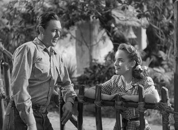 Movie still from “Mighty Joe Young” (1949), directed by Ernest B. Schoedsack – A man and a woman standing next to each other; Medium shot, Low angle