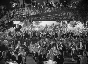 Movie still from “Mighty Joe Young” (1949), directed by Ernest B. Schoedsack – A black - and - white photo of people sitting at tables; Extreme Wide shot, High angle