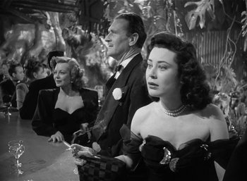 Movie still from “Mighty Joe Young” (1949), directed by Ernest B. Schoedsack – A man and two women are standing in a room; Medium shot, Low angle