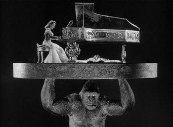 Movie still from “Mighty Joe Young” (1949), directed by Ernest B. Schoedsack – A gorilla holding a piano and a woman in a white dress; Medium shot, Low angle