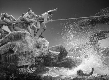 Movie still from “Mighty Joe Young” (1949), directed by Ernest B. Schoedsack – A group of men jumping off a rock into the water; Wide shot, High angle