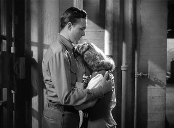 Movie still from “Mighty Joe Young” (1949), directed by Ernest B. Schoedsack – A man and a woman hugging in a doorway; Medium shot, Low angle