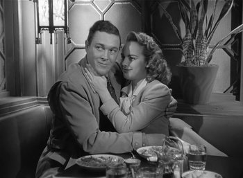 Movie still from “Mighty Joe Young” (1949), directed by Ernest B. Schoedsack – A man and a woman sitting at a table; Medium shot, Low angle