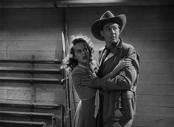 Movie still from “Mighty Joe Young” (1949), directed by Ernest B. Schoedsack – A man and a woman standing next to each other; Medium shot, Low angle