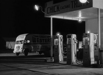 Movie still from “Mighty Joe Young” (1949), directed by Ernest B. Schoedsack – An old gas station at night with a bus parked at the gas pumps; Extreme Wide shot, Low angle