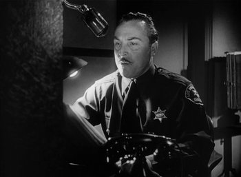 Movie still from “Mighty Joe Young” (1949), directed by Ernest B. Schoedsack – A black - and - white photo of a police officer; Close Up shot, Low angle