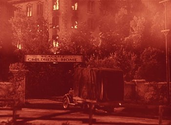 Movie still from “Mighty Joe Young” (1949), directed by Ernest B. Schoedsack – An old truck parked in front of a building at night; Extreme Wide shot, Low angle