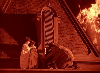 Movie still from “Mighty Joe Young” (1949), directed by Ernest B. Schoedsack – A man and a woman are sitting on the steps of a building; Wide shot, High angle