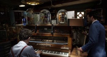 Movie still from “Mood Indigo” (2013), directed by Michel Gondry – A man playing a pipe organ in a room; Medium shot, High angle