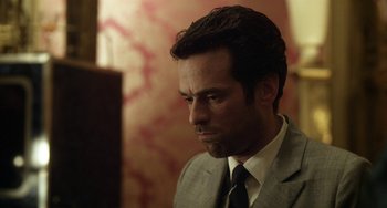 Movie still from “Mood Indigo” (2013), directed by Michel Gondry – A person wearing a suit and tie; Close Up shot, Over the shoulder angle