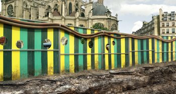 Movie still from “Mood Indigo” (2013), directed by Michel Gondry – A green and yellow wall with a building in the background; Extreme Wide shot, Low angle