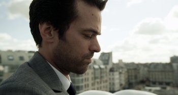 Movie still from “Mood Indigo” (2013), directed by Michel Gondry – A person wearing a suit and tie; Close Up shot, Low angle