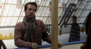 Movie still from “Mood Indigo” (2013), directed by Michel Gondry – A man wearing a scarf and gloves is leaning against a rail; Close Up shot, Over the shoulder angle