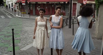 Movie still from “Mood Indigo” (2013), directed by Michel Gondry – Two young women are standing on the sidewalk; Medium shot, High angle