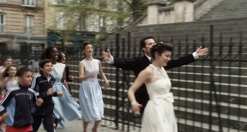 Movie still from “Mood Indigo” (2013), directed by Michel Gondry – A group of people dancing on a sidewalk; Wide shot, High angle