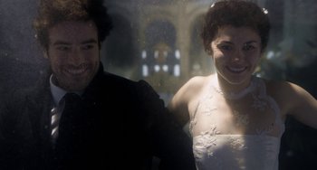Movie still from “Mood Indigo” (2013), directed by Michel Gondry – A man and a woman are standing next to each other in front of a window; Close Up shot, Overhead angle