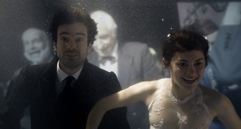 Movie still from “Mood Indigo” (2013), directed by Michel Gondry – A man and a woman standing next to each other in front of a window; Medium shot, Over the shoulder angle