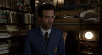 Movie still from “Mood Indigo” (2013), directed by Michel Gondry – A man wearing a suit and tie in a room; Close Up shot, Over the shoulder angle