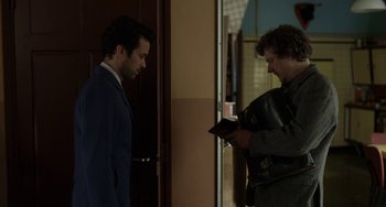 Movie still from “Mood Indigo” (2013), directed by Michel Gondry – Two men standing in front of a door looking at each other; Medium shot, Over the shoulder angle