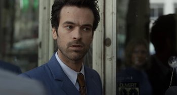 Movie still from “Mood Indigo” (2013), directed by Michel Gondry – A person wearing a suit and tie; Close Up shot, Over the shoulder angle