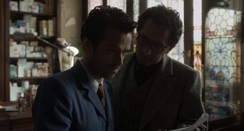 Movie still from “Mood Indigo” (2013), directed by Michel Gondry – Two men in suits looking at something on a tablet; Close Up shot, Over the shoulder angle