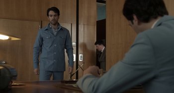 Movie still from “Mood Indigo” (2013), directed by Michel Gondry – A man standing in front of a mirror in a room; Medium shot, Over the shoulder angle