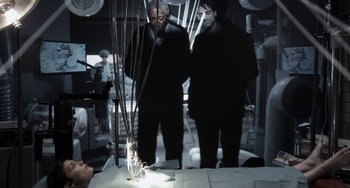 Movie still from “Mood Indigo” (2013), directed by Michel Gondry – Two people standing in a room with wires hanging from the ceiling; Medium shot, Over the shoulder angle
