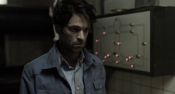 Movie still from “Mood Indigo” (2013), directed by Michel Gondry – A man in a blue shirt is standing in a room; Close Up shot, Over the shoulder angle