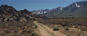 Movie still from “Nevada Smith” (1966), directed by Henry Hathaway – A dirt road going through the middle of the desert; Extreme Wide shot, Low angle