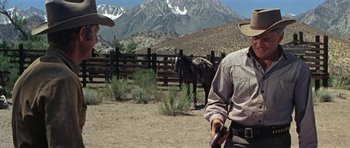 Movie still from “Nevada Smith” (1966), directed by Henry Hathaway – A man standing in front of a horse in a corral; Medium shot, Low angle
