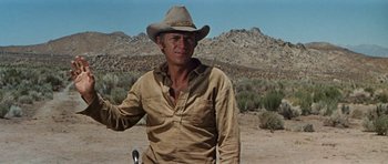 Movie still from “Nevada Smith” (1966), directed by Henry Hathaway – A man wearing a cowboy hat standing in the desert; Medium shot, Low angle