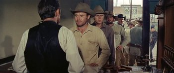 Movie still from “Nevada Smith” (1966), directed by Henry Hathaway – A group of men standing next to each other in a room; Medium shot, Over the shoulder angle