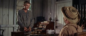 Movie still from “Nevada Smith” (1966), directed by Henry Hathaway – A man standing in front of a desk with a laptop; Medium shot, Over the shoulder angle