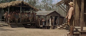 Movie still from “Nevada Smith” (1966), directed by Henry Hathaway – A group of people standing on top of a wooden structure; Wide shot, Low angle