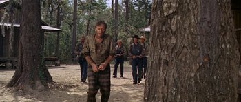 Movie still from “Nevada Smith” (1966), directed by Henry Hathaway – A group of men standing next to a tree; Wide shot, Low angle
