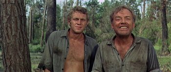 Movie still from “Nevada Smith” (1966), directed by Henry Hathaway – Two shirtless men standing next to each other in the woods; Medium shot, Low angle