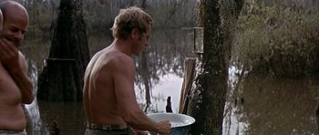 Movie still from “Nevada Smith” (1966), directed by Henry Hathaway – A shirtless man washing a bird in a bowl; Medium shot, Over the shoulder angle