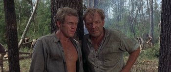 Movie still from “Nevada Smith” (1966), directed by Henry Hathaway – A couple of men standing next to each other near a tree; Medium shot, Low angle