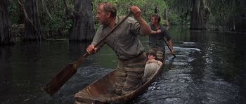 Movie still from “Nevada Smith” (1966), directed by Henry Hathaway – A group of men paddling a canoe down a river; Wide shot, Low angle
