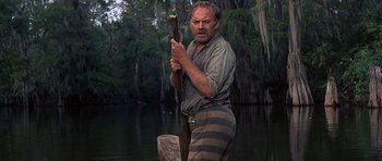 Movie still from “Nevada Smith” (1966), directed by Henry Hathaway – A man holding an oar while standing in a body of water; Medium shot, Low angle