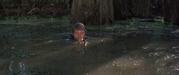 Movie still from “Nevada Smith” (1966), directed by Henry Hathaway – A man in a body of water holding a gun; Medium shot, Low angle