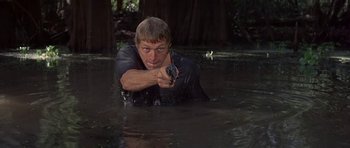 Movie still from “Nevada Smith” (1966), directed by Henry Hathaway – A man in a body of water holding a gun; Medium shot, Low angle